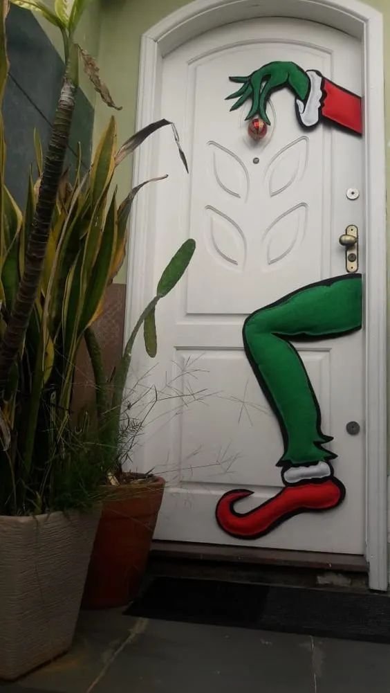 Playful Grinch-themed Christmas decor on a front door, adding a whimsical holiday touch.