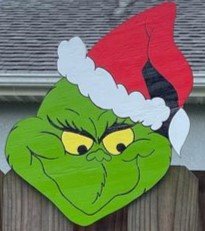 Grinch Christmas decor sign on a fence, bringing a fun and festive holiday spirit to outdoor decorations.